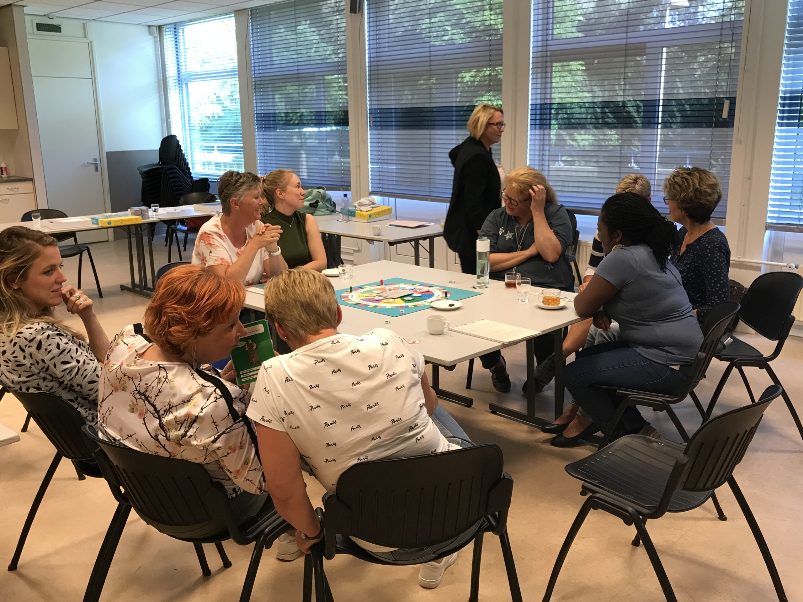 Deelnemers van een Team Toppers training rond het speelbord